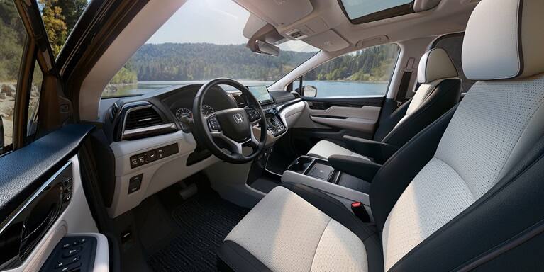 2027 Honda Odyssey Elite front cabin featuring perforated leather seats and dashboard (Minivan).