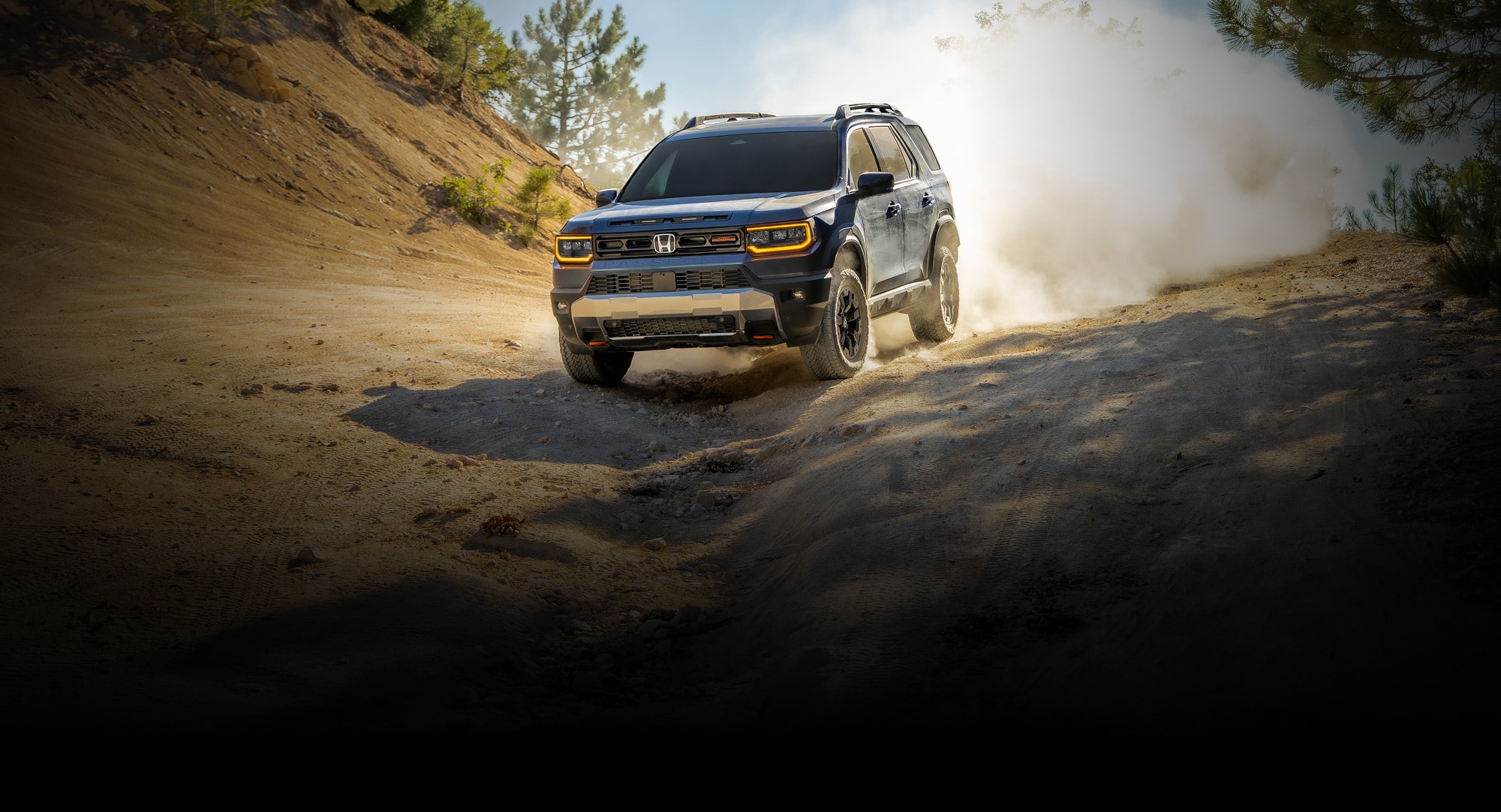 2027 Honda Passport TrailSport in Smoke Blue Pearl front driving on a dusty off-road trail (Mid-Size SUV).